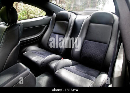 Schalensitze in der Rückseite eines schnellen roten Sportwagen. Von schwarzen und dunklen Grau oder anthrazit Stoff und Leder. Für Komfort und Sicherheit ausgelegt. Stockfoto