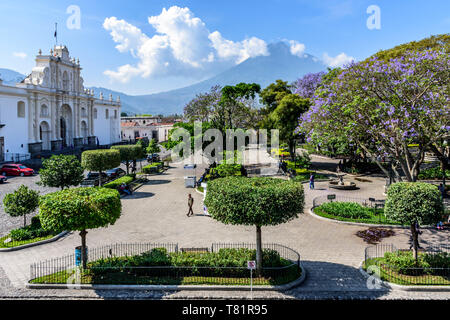 Antigua, Guatemala - April 10, 2019: Kathedrale San José mit Blick auf den Central Park mit Agua Vulkan hinter in der kolonialen Stadt und UNESCO-Weltkulturerbe. Stockfoto