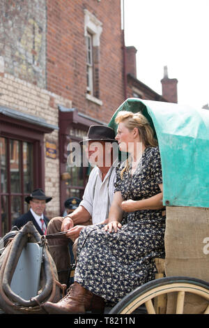 Nahaufnahme von Ehepaar in Wagen von Pferd draußen in vintage Street an Black Country Museum, Dudley, Großbritannien, 1940 Wochenende zog sitzt, Sommer 2018. Stockfoto