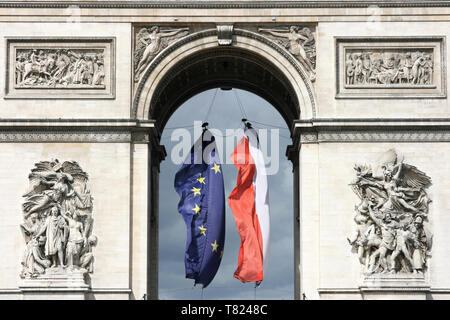 Das Wahrzeichen von Paris, Frankreich. Arc de Triomphe (Triumphbogen) am Place Charles de Gaulle entfernt. Flaggen der EU und Frankreich. Stockfoto