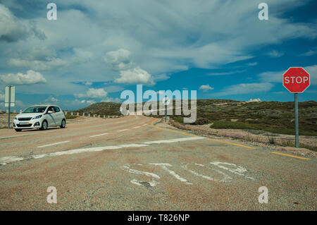 Auto durch Straße mit STOP traffic sign auf felsigen Landschaft der Serra da Estrela. Das höchste Gebirge auf dem portugiesischen Festland. Stockfoto