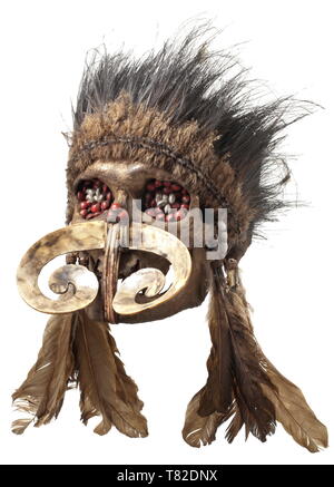 Ein ahnenschädel der Asmat Menschen, Papua Neuguinea, dunkel patiniert Schädel eines alten Mannes, der Kiefer durch Gewebte rattan Bands statt durch die Nase öffnen und cord Umhüllungen in der Gemeinsamen. Die Augenhöhlen und nasalen Knochen mit einem dunklen Masse mit farbigen Samen gefüllt. Große Nase Dekoration aus ein Schneckenhaus. Kunstvoll geflochtenen Kopfschmuck der verschiedenen Vogelfedern. Die Spuren des Alters. Höhe 18 cm. Die Schädel von geschätzten Vorfahren, so genannte "Ndambirkus", wurden Objekte der Verehrung. Sie wurden aufwendig dekoriert und in einem Saf gehalten, Additional-Rights - Clearance-Info - Not-Available Stockfoto