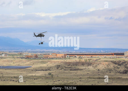 Ein UH-60 Black Hawk, die von Mitgliedern des 4 Combat Aviation Brigade pilotiert, 4 Infanterie Division, wählt einen M119 Haubitze, 2. Mai 2019, während Air Assault Training mit Soldaten Bravo. Akku, 2. Battalion, 77th Field Artillery Regiment, 2 Infantry Brigade Combat Team, 4. Inf. Div., auf Fort Carson, Colorado. (U.S. Armee Foto: Staff Sgt. Neysa Canfield) Stockfoto