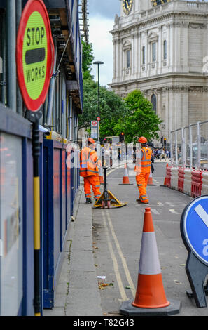 City of London, London, England, UK - August 3, 2017: Zwei Verkehr Marschälle gekleidet in Orange arbeiten auf einem unbenutzten Busspur. Stockfoto