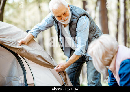 Senior Paar vorbereiten für Rest, ein Zelt im Wald Stockfoto