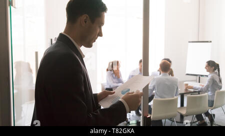 Besorgt männlichen Moderator lesen Schreibarbeiten vor der Vorlage Stockfoto