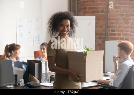 Aufgeregt schwarze weibliche Newcomer Holding Box mit persönlichem Eigentum Stockfoto