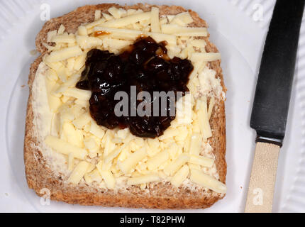 Geriebener Cheddar-Käse mit Branston pickle auf Vollkornbrot Stockfoto