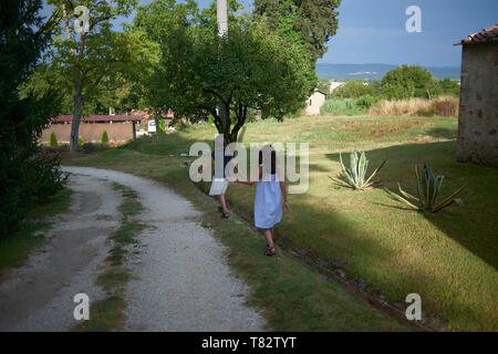 Zwei asiatische Mädchen zu Fuß auf einen Weg in eine schöne Landschaft in der Toskana in Italien die Erkundung der Platz, während in den Urlaub Stockfoto