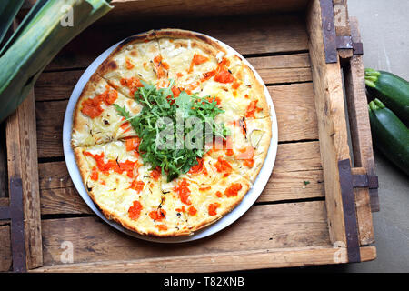Appetitliche Pizza, einen Teller auf einem Körper Holztisch. Horizontale Komposition. Ansicht von oben. Stockfoto