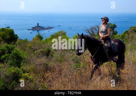 Frankreich, Var, Roquebrune-sur-Bereich neben Saint Raphael, Reiter Trekking im Massif de l'Esterel (Esterel Massif) und die Ile d'Or Dramont Insel am Kap im Hintergrund Stockfoto