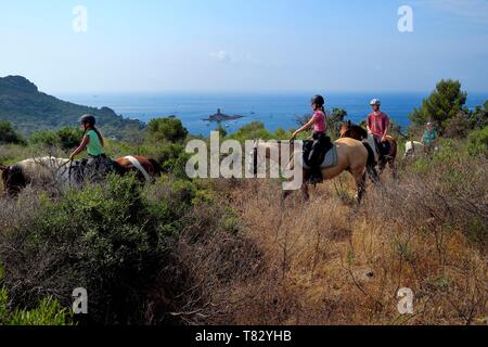 Frankreich, Var, Roquebrune-sur-Bereich neben Saint Raphael, Reiter Trekking im Massif de l'Esterel (Esterel Massif) und die Ile d'Or Dramont Insel am Kap im Hintergrund Stockfoto