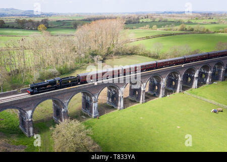 Stanway Viadukt, in der Nähe von Toddington, Gloucestershire, UK. Frühling liegt in der Luft. Eine Dampflokomotive kreuzt die Stanway Viadukt in Gloucestershire Stockfoto