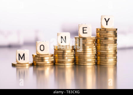 Steigende Stapel von Münzen mit dem Wort Geld Stockfoto