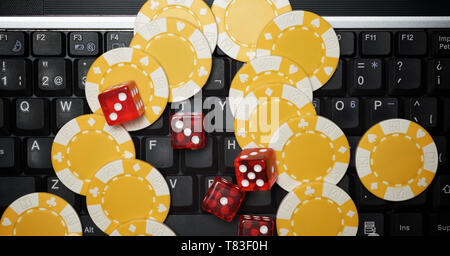 Casino Chips und Würfel Stapeln auf einem Laptop. Stockfoto