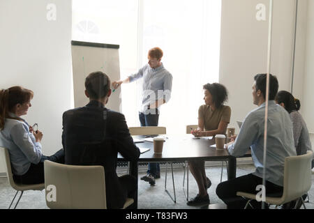 Männliche Trainer flipchart Präsentation machen für unterschiedliche Mitarbeiter Stockfoto