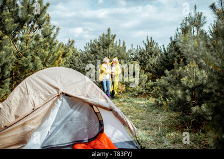 Senior Paar in gelben Regenjacken auf dem Campingplatz im Jungen Wald Stockfoto