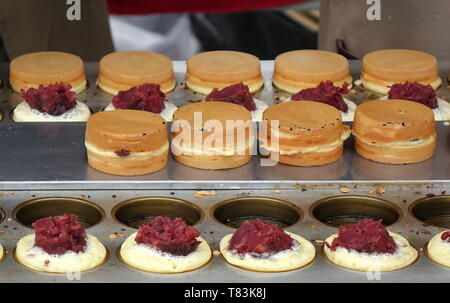 Einen Auftragnehmer im süßen roten bean Kuchen, einem beliebten chinesischen Imbiss. Stockfoto