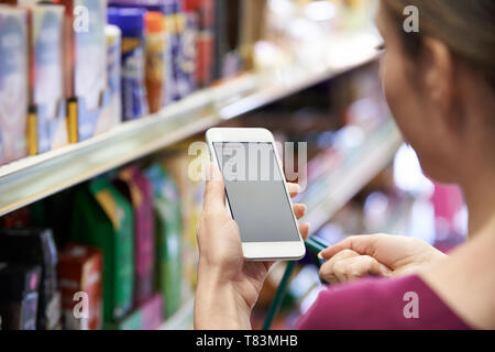 Nahaufnahme von Frau Lesung Einkaufsliste von Handy Stockfoto