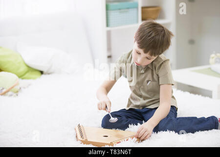 Ein Kind mit einem Musikinstrument. Jungen lernen Hackbrett spielen Stockfoto