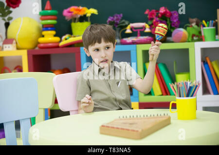 Ein Kind mit einem Musikinstrument. Jungen lernen Hackbrett spielen Stockfoto