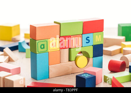 Autismus Schriftzug aus bunten Bausteinen auf Holz- Oberfläche isoliert auf weißem Stockfoto