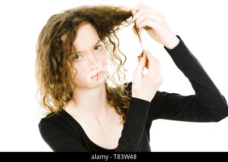 Teenaged blonde Mädchen mit lockigem Haar in wirren Haare problem - Ausgefransten Haarspitzen, müssen Qualität Shampoo - Weißer Hintergrund Stockfoto