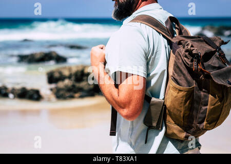 In der Nähe von erwachsenen Menschen kaukasischen Mann reisen mit Leder style Rucksack - alternative traveler Urlaub Outdoor Konzept und Strand Meer im Hintergrund Stockfoto