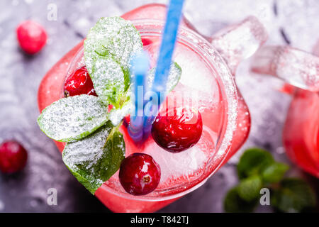 Iced hausgemachte Limonade mit Preiselbeeren, Zitrusfrüchte und frischer Minze Blatt in einem Cocktail Glas mit Strohhalm Stockfoto