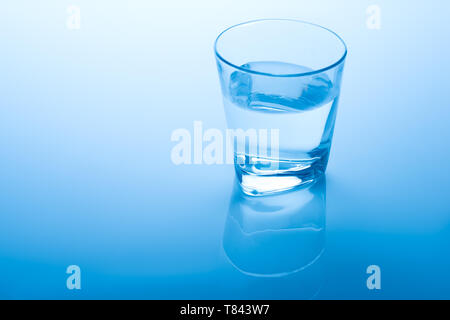 Glas Wasser auf blauem Hintergrund Stockfoto