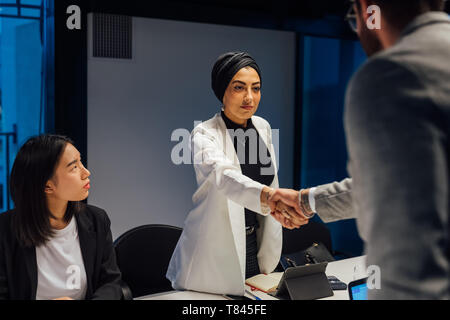 Geschäftsfrau und männlichen Klienten Händeschütteln über Konferenz Tisch Stockfoto