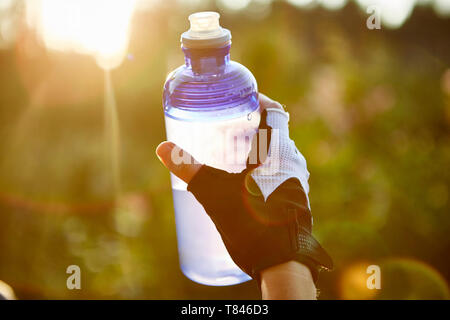 Weibliche Radfahrer holding Wasserflasche, Nahaufnahme einer Hand, Stockfoto