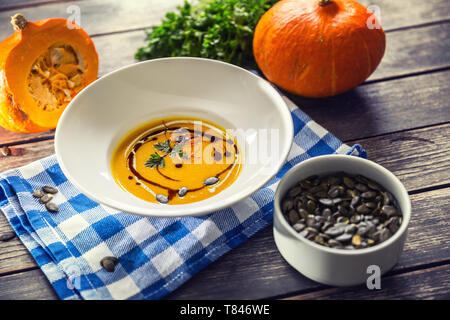 Kürbis Cremesuppe mit Samen und Petersilie auf dem Küchentisch Stockfoto