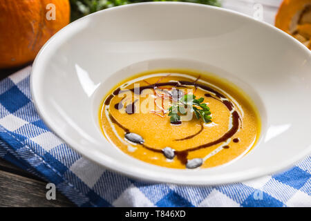 Kürbis Cremesuppe mit Samen und Petersilie auf dem Küchentisch Stockfoto