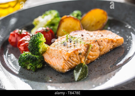 Gebratenes Lachsfilet broccoli Tomaten und Bratkartoffeln mit Dill Sauce Stockfoto