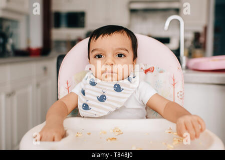 Cute Baby boy in hoher Stuhl sitzen, Porträt Stockfoto