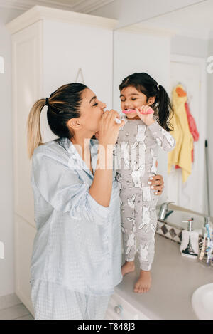 Mädchen und Mutter putzen ihre Zähne im Badezimmer Stockfoto