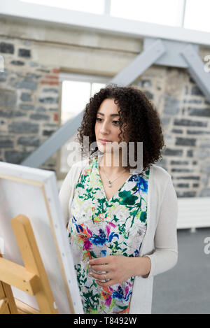 Junge weibliche Maler Malerei Leinwand im Studio Stockfoto