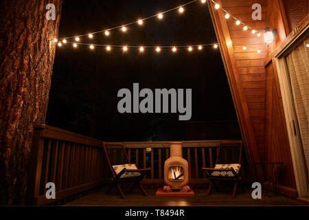 Kamin und zwei korbstühle auf der Veranda des Hauses Stockfoto