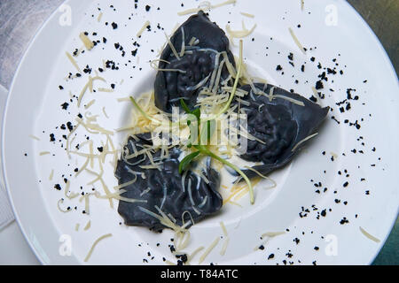 Ravioli mit Tintenfisch Tinte, Sauce und Käse. Stockfoto