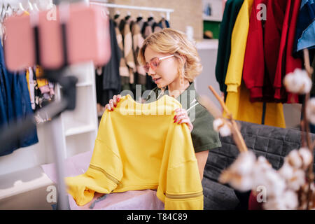 Junge stilvolle Frau in Nizza Sonnenbrille Dreharbeiten blog über Kleidung Stockfoto