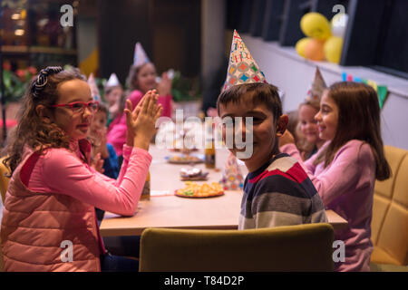 Der junge freudig feiert seinen Geburtstag mit einer Gruppe seiner Freunde Stockfoto