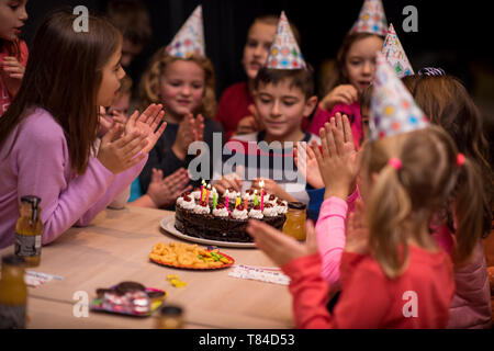 Der junge freudig feiert seinen Geburtstag mit einer Gruppe seiner Freunde Stockfoto