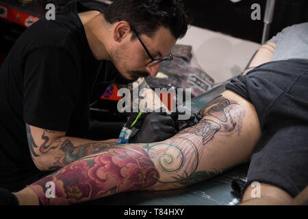 Athen, Griechenland. 10. Mai, 2019. Ein tattoo Artist gesehen Arbeiten an einen Kunden während der Internationalen Tattoo-convention. Tausende Tattoo Künstler der ganzen Welt während des 13 Athens International Tattoo Convention nahmen und sie auch Tattoos für Menschen, die interessiert waren. Credit: Nikolas Joao Kokovlis/SOPA Images/ZUMA Draht/Alamy leben Nachrichten Stockfoto