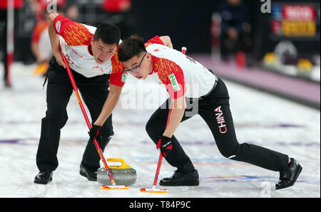 Peking, China. 11. Mai, 2019. Ba Dexin (L) von China fegt während der 2018-1019 WCF-Curling Wm Grand Final sechste Runde zwischen China und Kanada an der Shougang Park Shijingshan Distrikt in Peking, der Hauptstadt von China, 11. Mai 2019. Credit: Luo Yuan/Xinhua/Alamy leben Nachrichten Stockfoto