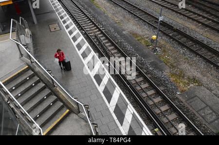 München, Deutschland. 11. Mai, 2019. Eine Frau geht über leere Plattform mit ihrem Gepäck. Die S-Bahn der Linie zwischen Pasing und Ostbahnhof ist wegen Wartungsarbeiten geschlossen. Quelle: Angelika Warmuth/dpa/Alamy leben Nachrichten Stockfoto