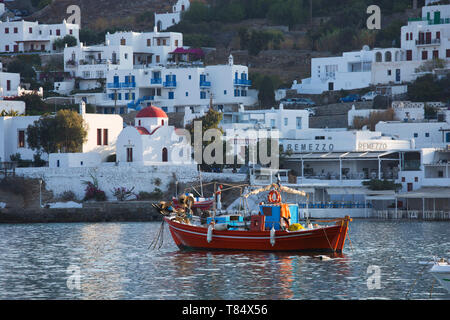 Mykonos Stadt, Mykonos, südliche Ägäis, Griechenland. Bunte Fischerboote im Hafen, rot-gewölbte Kirche im Hintergrund. Stockfoto