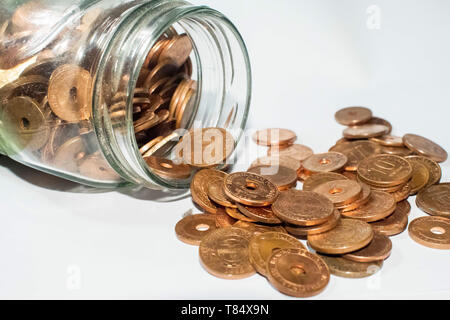 Glas Glas voller kleiner Goldmünzen und Münzen aus Glas Glas kommen Stockfoto