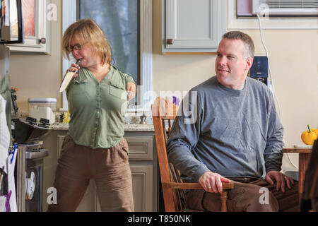 Frau mit TAR-Syndrom herauf ein Messer mit ihrem Mann in der Küche Stockfoto