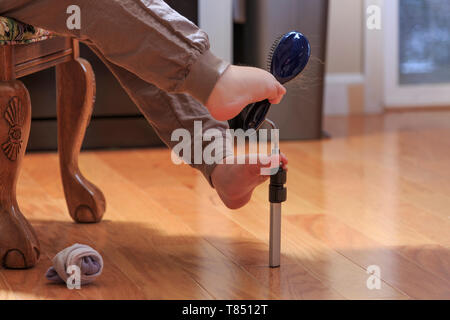 Frau mit TAR-Syndrom sie ihr Haar Bürste mit ihren Füßen Stockfoto